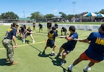 Petty Officer 1st Class Sarah Salazar cheers on future Sailor and future Soldiers during tug-of-war in San Antonio, June 17. This event encouraged communication, teamwork and mutual support.