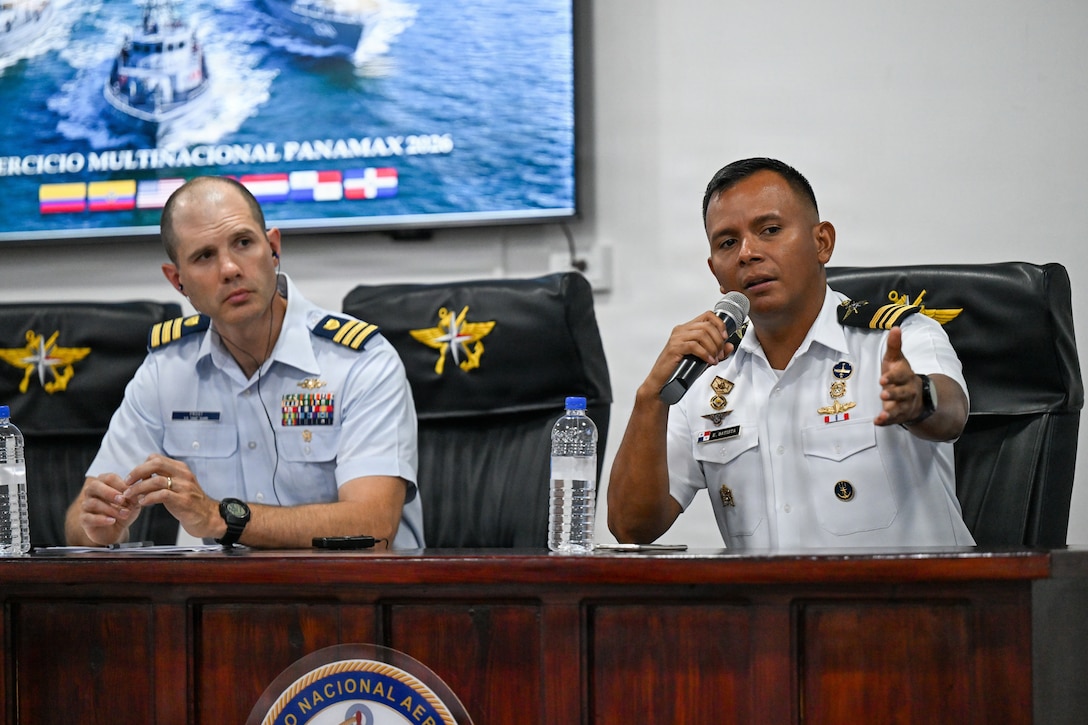 A U.S. Coast Guard service member sits next to Panamanian National Aeronaval Service Maj. Eduardo Batista speaks