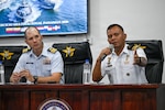 A U.S. Coast Guard service member sits next to Panamanian National Aeronaval Service Maj. Eduardo Batista speaks