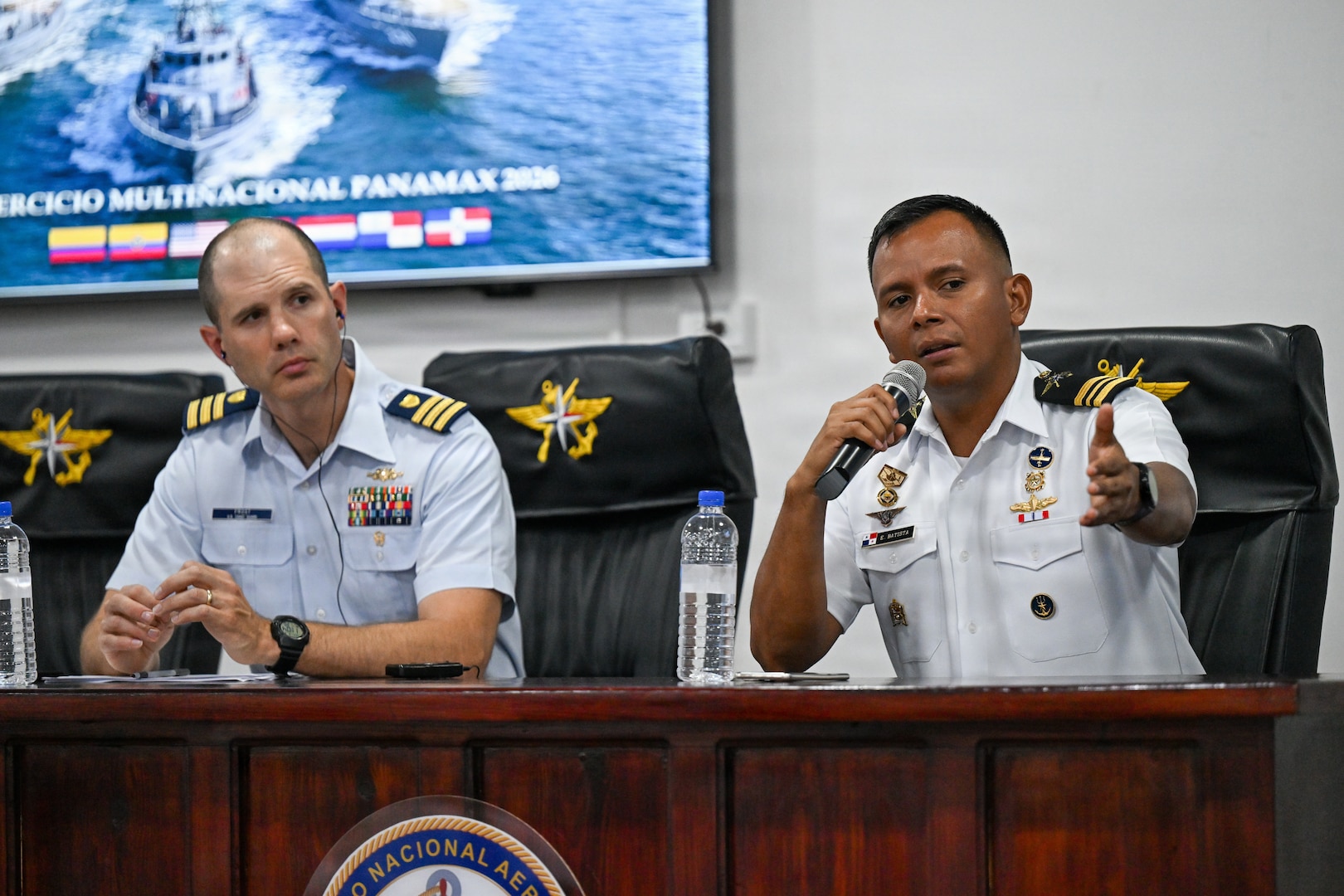 A U.S. Coast Guard service member sits next to Panamanian National Aeronaval Service Maj. Eduardo Batista speaks