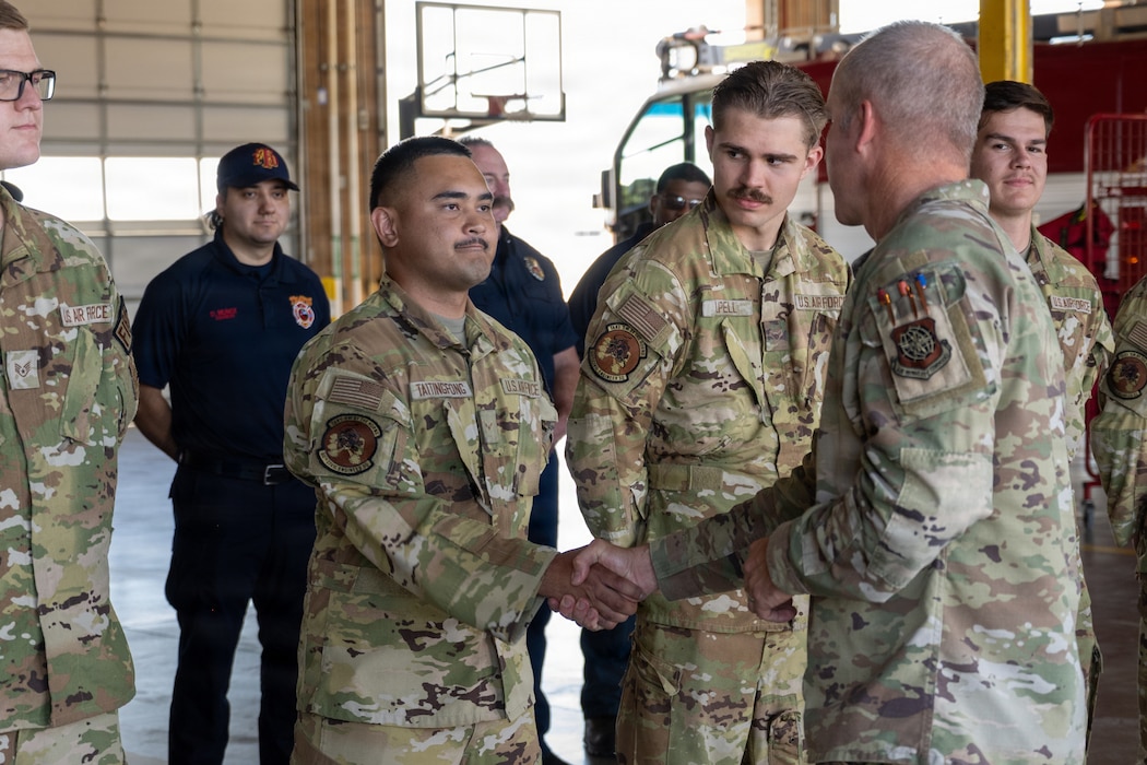 Airman receives a coin from the commander.