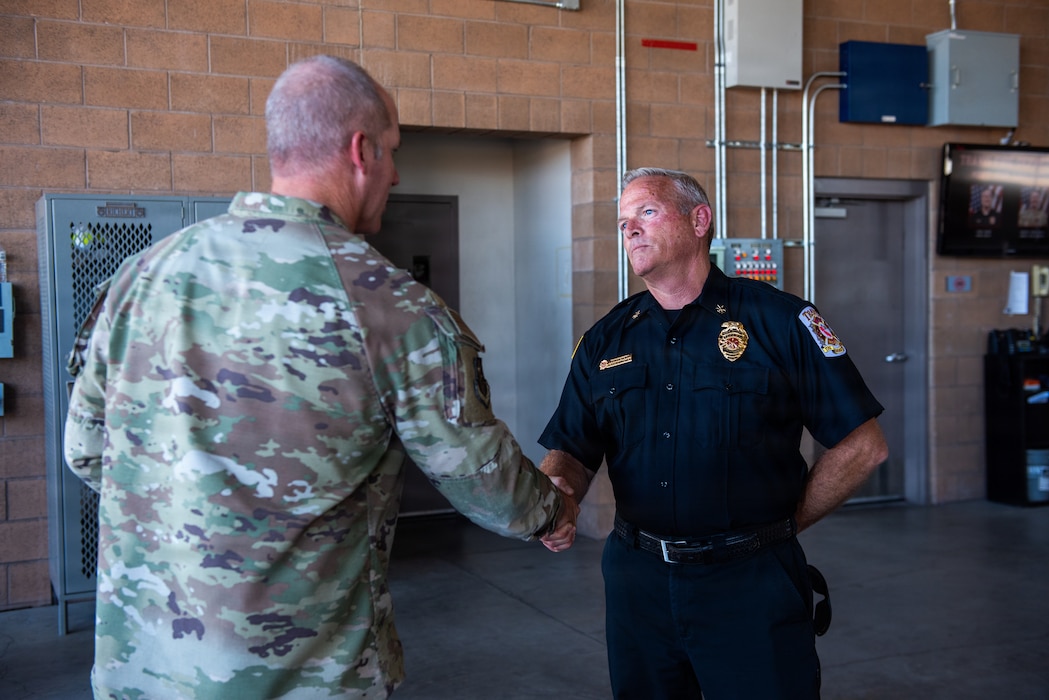 Commander presents a coin to an Airman.