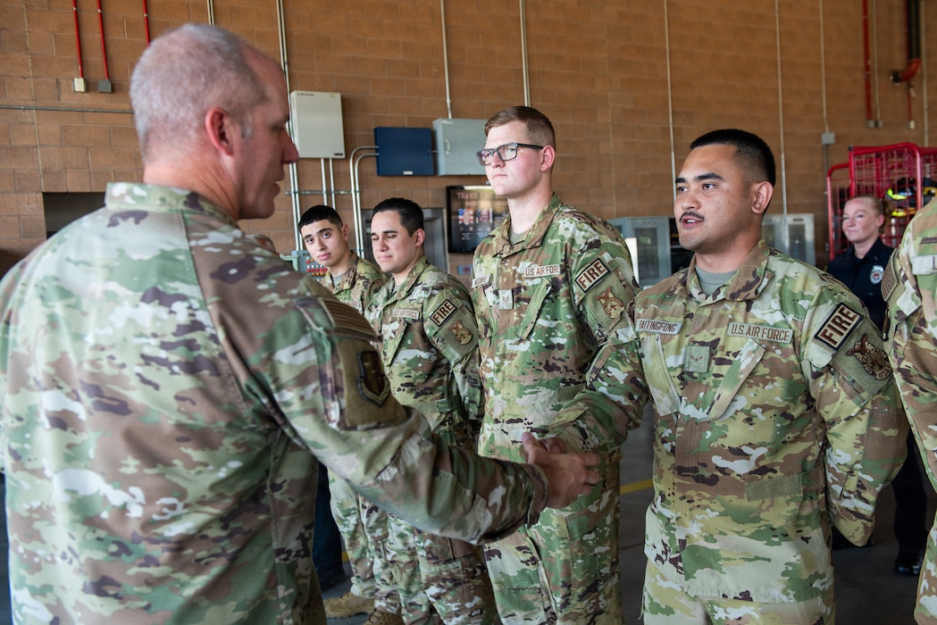 Commander presents a coin to an Airman.