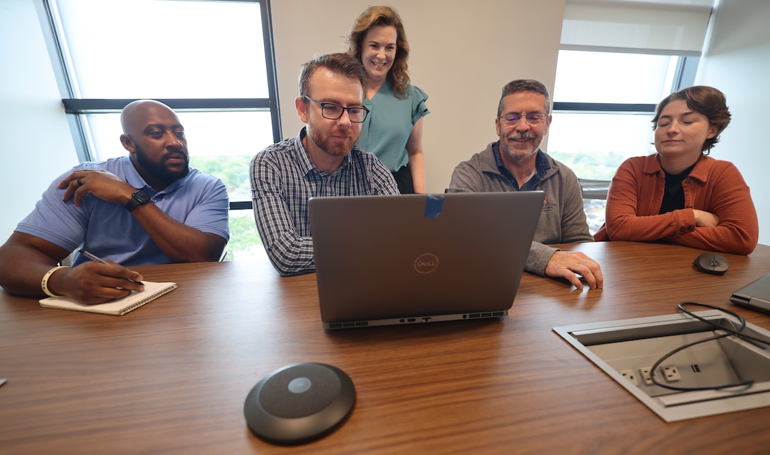 Timothy “Jay” Caldwell II, U.S. Army Corps of Engineers, Mobile District cost engineer, center, leads the Cost Section team in a review of material at the Mobile District Office, Mobile, Alabama, Aug. 3, 2026. Caldwell recently was named the USACE Cost Engineer of the Year for MILCON for the 2026 Engineering and Construction Community of Practice Awards. (U.S. Army photo by Chuck Walker)
