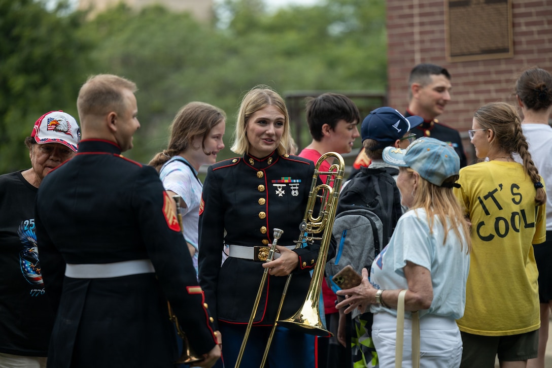 U.S. Marine Corps Cpl. Morgan Lavis, from Michigan, right, and U.S. Marine Corps Sgt. Trevor Halley, from Ohio, musicians with the 2nd Marine Aircraft Wing Band, talks with spectators during the 49th annual Sturgis Falls Celebration at Cedar Falls, Iowa, June 27, 2026. The 2nd MAW Band took part in the celebration to strengthen community relations and reaffirm the history, customs, and traditions representative of the Marine Corps. (U.S. Marine Corp photo by Pfc. Keani Guthmueller)