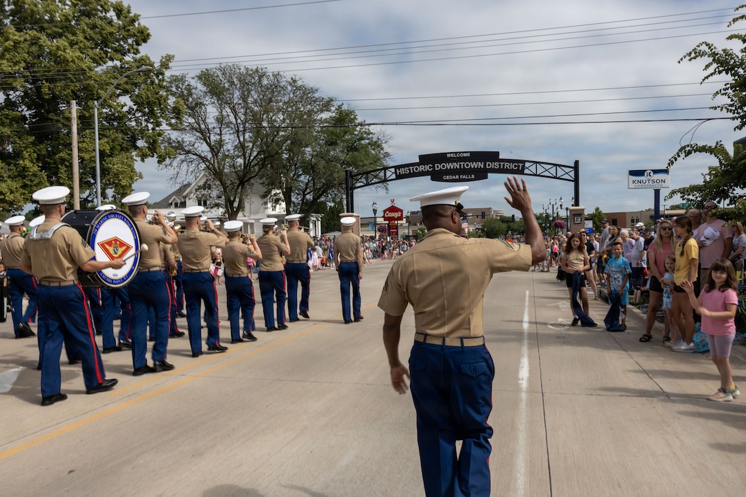 U.S. Marine Corps Cpl. Tannah Morris, from New Jersey, musician with the 2nd Marine Aircraft Wing Band, waves to the spectators during the 49th annual Sturgis Falls Celebration at Cedar Falls, Iowa, June 27, 2026. The 2nd MAW Band took part in the celebration to strengthen community relations and reaffirm the history, customs, and traditions representative of the Marine Corps. (U.S. Marine Corp photo by Pfc. Keani Guthmueller)