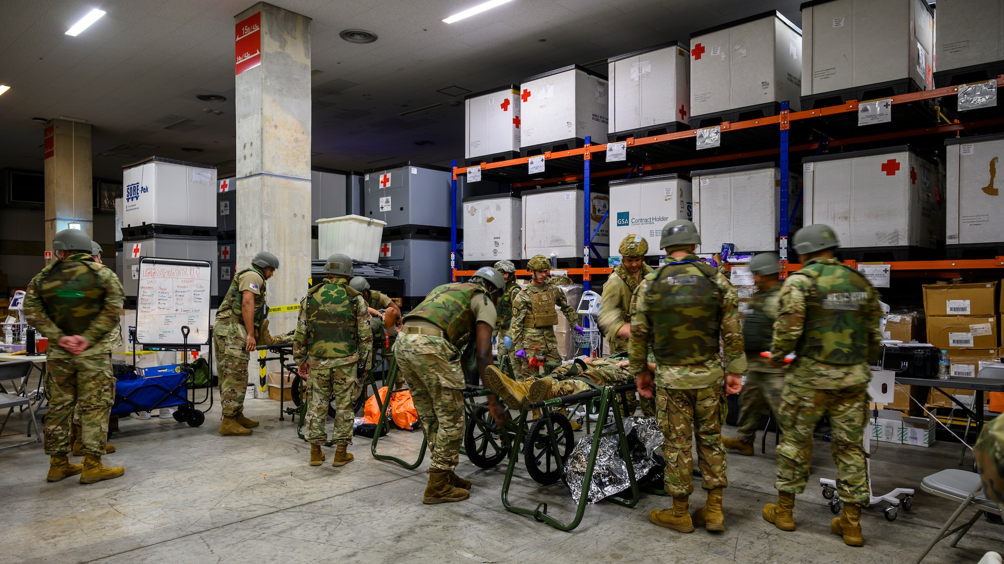 U.S. Air Force medical personnel assigned to the 18th Medical Group examine two simulated patients during an En-Route Patient Staging System exercise as part of Beverly Beach 26-1 at Kadena Air Base, Japan, Aug. 4, 2026. The exercise tested the unit's ability to rapidly receive, stabilize and prepare patients for aeromedical evacuation in an expeditionary environment. (U.S. Air Force photo by Airman 1st Class Francisco Huerta)