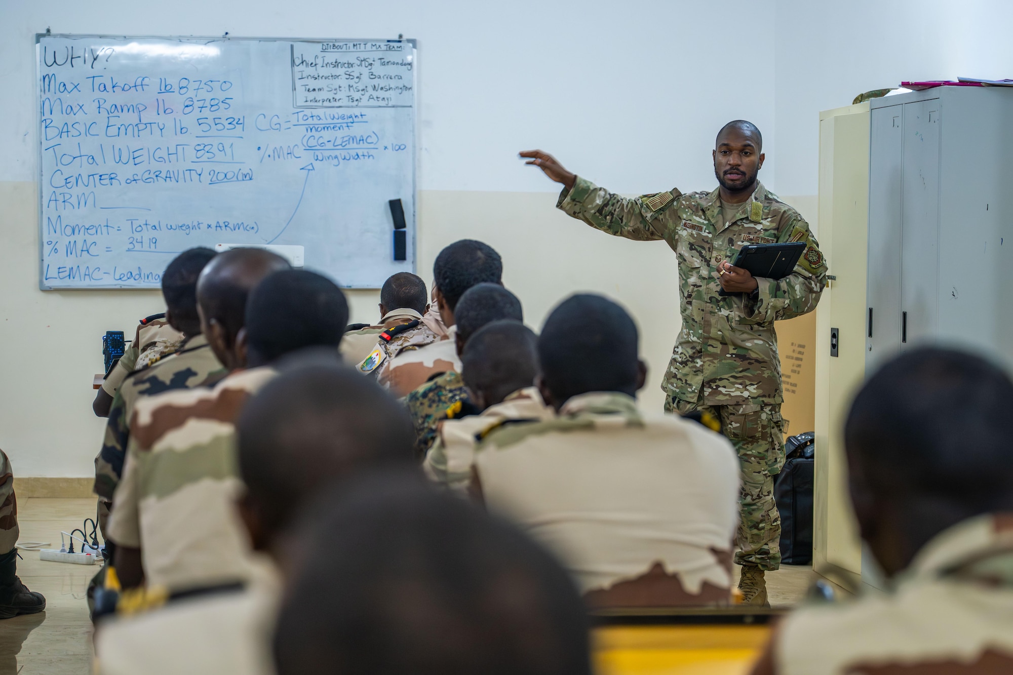 a military member instructs a room full of military students.