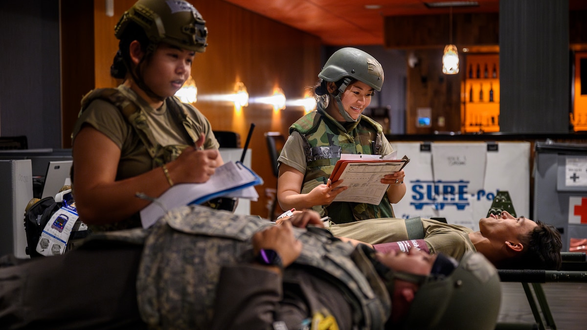 U.S. Air Force Capt. Saidel Sunga, left, and Capt. Manami Jones, 18th Medical Group clinical nurses, monitor simulated patients inside an En-Route Patient Staging System facility before aeromedical evacuation during Beverly Beach 26-1 at Kadena Air Base, Japan, Aug. 4, 2026. The exercise validated the 18th MDG's ability to provide en-route patient care and support patient movement operations during contingency scenarios. (U.S. Air Force photo by Airman 1st Class Francisco Huerta)