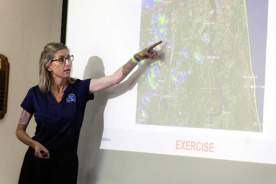 Angela Enyedi, warning coordination meteorologist with the National Weather Service Jacksonville, briefs emergency management personnel from four Northeast Florida military installations and partner agencies during a facility incident readiness exercise Aug. 4, 2026, at Orange Park Town Hall in Orange Park, Florida. Enyedi outlined the simulated drought and wildfire conditions used to test regional coordination and emergency response. (U.S. Marine Corps photo by Dustin Senger)