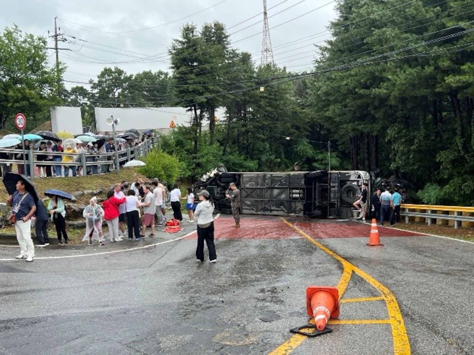 A tour bus sits overturned on a roadway in Paju, Republic of Korea, June 20, 2026. Off-duty U.S. Airmen and Soldiers sprang into action after the bus overturned, assisting injured passengers until emergency services arrived.
