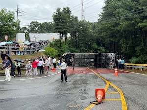 A tour bus sits overturned on a roadway in Paju, Republic of Korea, June 20, 2026. Off-duty U.S. Airmen and Soldiers sprang into action after the bus overturned, assisting injured passengers until emergency services arrived.