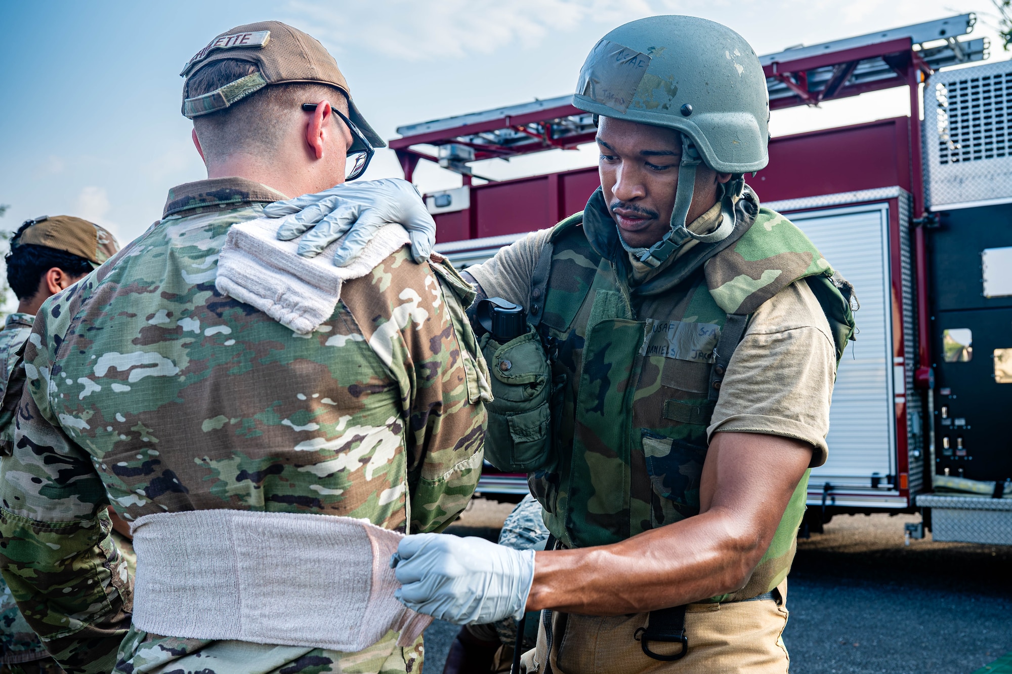 Service member applies bandages to simulated patient.