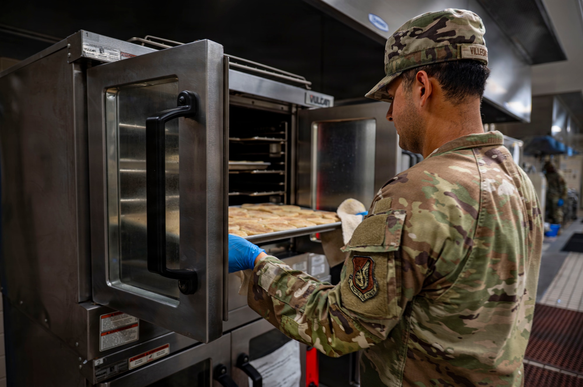 A person takes biscuits out of the oven