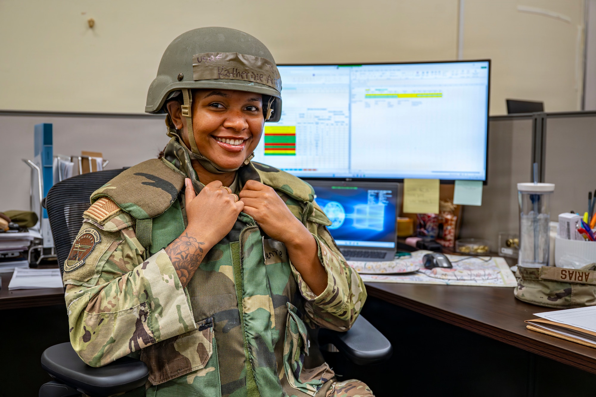 A person poses for a portrait in front of her desk