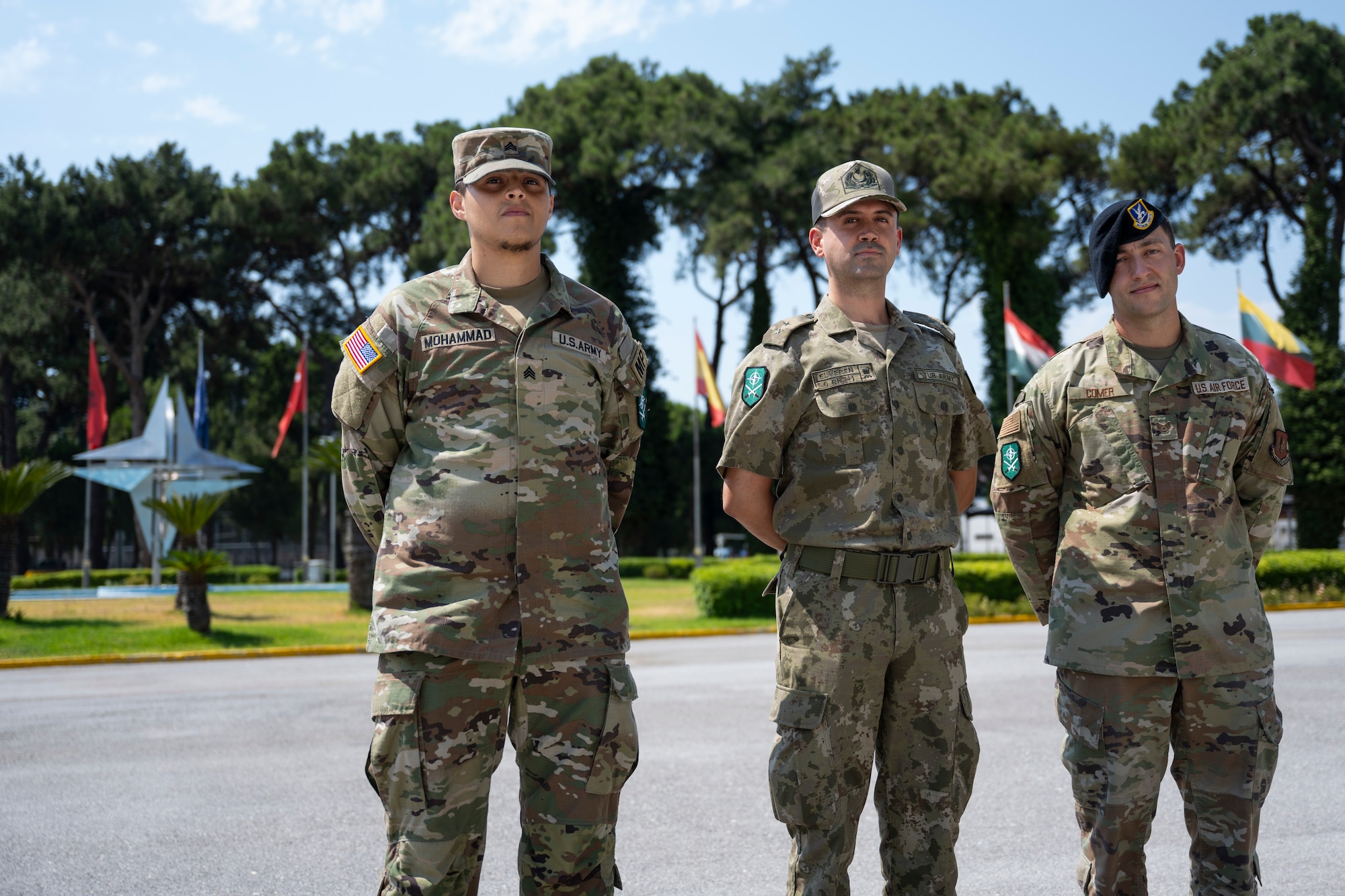 Personnel standing in front of a NATO statue