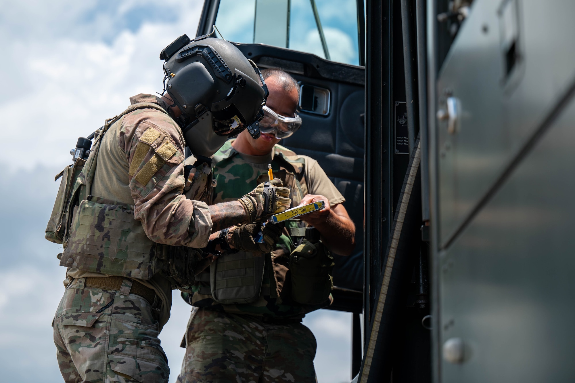 U.S. Air Force Airman 1st Class Joshua Vasquez, right, 18th Logistics Readiness Squadron petroleum, oil and lubricants distribution operator, completes fuel documentation with a U.S. Air Force 33rd Rescue Squadron special mission aviator, left, following the refueling of an HH-60W Jolly Green II during a hot-gas refueling operation as part of readiness exercise Beverly Beach 26-1 at Kadena Air Base, Japan, Aug. 4, 2026. Rapid aircraft turnaround strengthens the 18th Wing's ability to sustain airpower and respond to evolving operational requirements across the Indo-Pacific. (U.S. Air Force photo by Airman 1st Class Nathaniel Jackson)