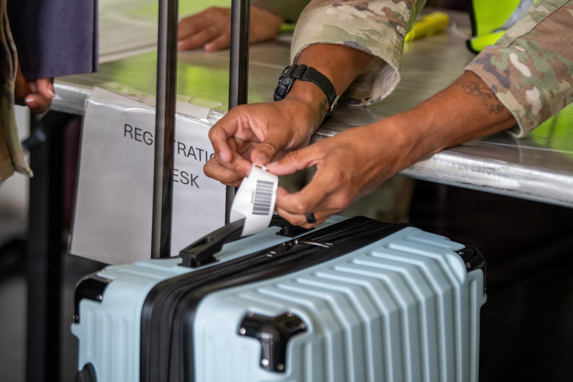 U.S. Air Force service member assigned 18th Wing tags a bag in a simulated military assisted departure training during readiness
