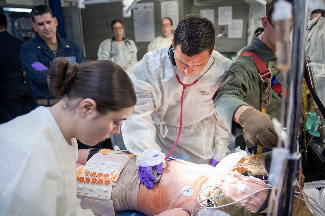 260716-N-GT162-1129 U.S. Navy Sailors assigned to Nimitz-class aircraft carrier USS Theodore Roosevelt (CVN 71) check vitals on a training mannequin for a casualty receiving drill during Exercise Rim of the Pacific 2026 in the Pacific Ocean, July 16, 2026. Thirty nations, 30 ships, five submarines, 15 national land forces, more than 190 aircraft and more than 30,000 personnel are participating in RIMPAC in and around the Hawaiian Islands, June 24 to July 31. The world's largest international maritime exercise, RIMPAC provides a unique training opportunity while fostering and sustaining cooperative relationships among participants critical to ensuring the safety of sea lanes and security on the world's oceans. RIMPAC 2026 is the 30th exercise in the series that began in 1971. (U.S. Navy photo by Mass Communication Specialist Seaman Alex Lutje)