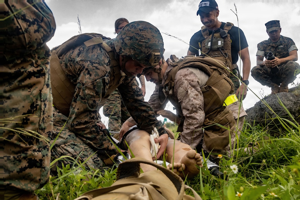 260624-M-RK059-1306 U.S. Marine Corps Cpl. Adam Chvala, left, a utilities systems technician, and U.S. Navy Hospital Corpsman 2nd Class Rodrigo Becerrilmora, both with Marine Wing Support Squadron 172, Marine Aircraft Group 36, 1st Marine Aircraft Wing, apply bandages to a simulated casualty during a Tactical Combat Casualty Care Combat Medic/Corpsman course at Marine Corps Air Station Futenma, Okinawa, Japan, June 24, 2026. The CMC course trained participants to give advanced medical treatment to casualties in combat situations. (U.S. Marine Corps photo by Sgt. Gabriel Antwiler)