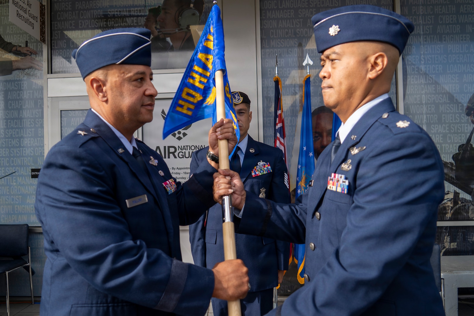 Air Force Brig. Gen. Phillip L. Mallory, Hawaii Air National Guard commander, passes the Headquarters Hawaii Air National Guard Recruiting and Retention Flight guidon to Air Force Lt. Col. Michael Buendia, Headquarters Hawaii Air National Guard Recruiting Flight commander, symbolizing Buendia's acceptance of command of the flight during the unit's activation ceremony held at Pearl Highlands Center in Pearl City, Hawaii, Aug. 1, 2026.