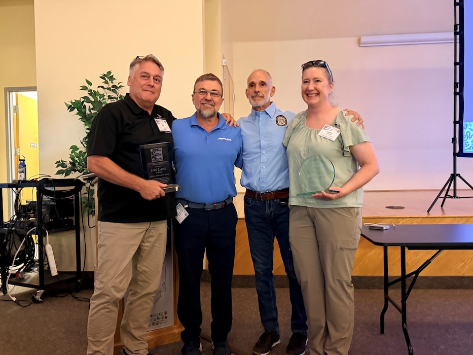 Jacksonville District’s Invasive Species Management Branch Chief, Jon Lane (left) and Biologist Jessica Spencer (right), flank the ECSIMA Co-chairs, Mr. LeRoy Rodgers, SFWMD and Mr. Dennis Giardina, FWC, after receiving the Association’s Lifetime Achievement and Partner of the Year Awards respectively at the 2026 ECISMA Summit in Davie, Florida. (USACE photo by Peggy Bebb)