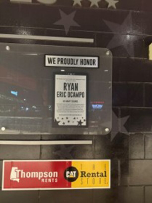 A sign on a stadium jumbotron posts a plaque
