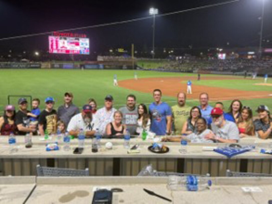 A group photo of people at a baseball game
