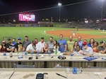 A group photo of people at a baseball game