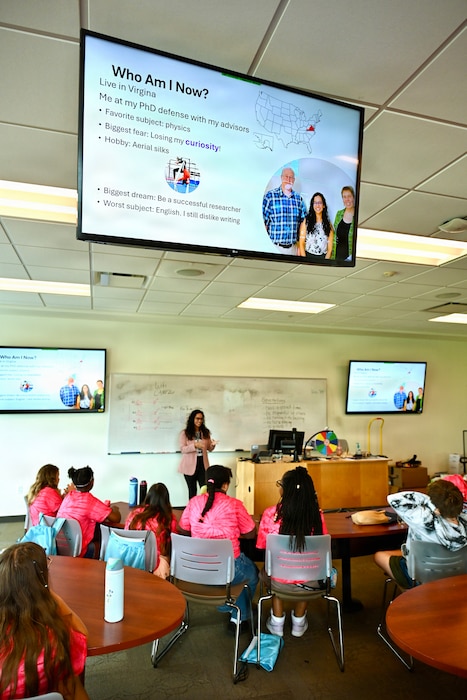 Guest speaker Charris Gabaldon, a NIWC Atlantic physicist embedded at NASA Langley, addresses middle school students at a podium during the STEM Rocks! summer camp.