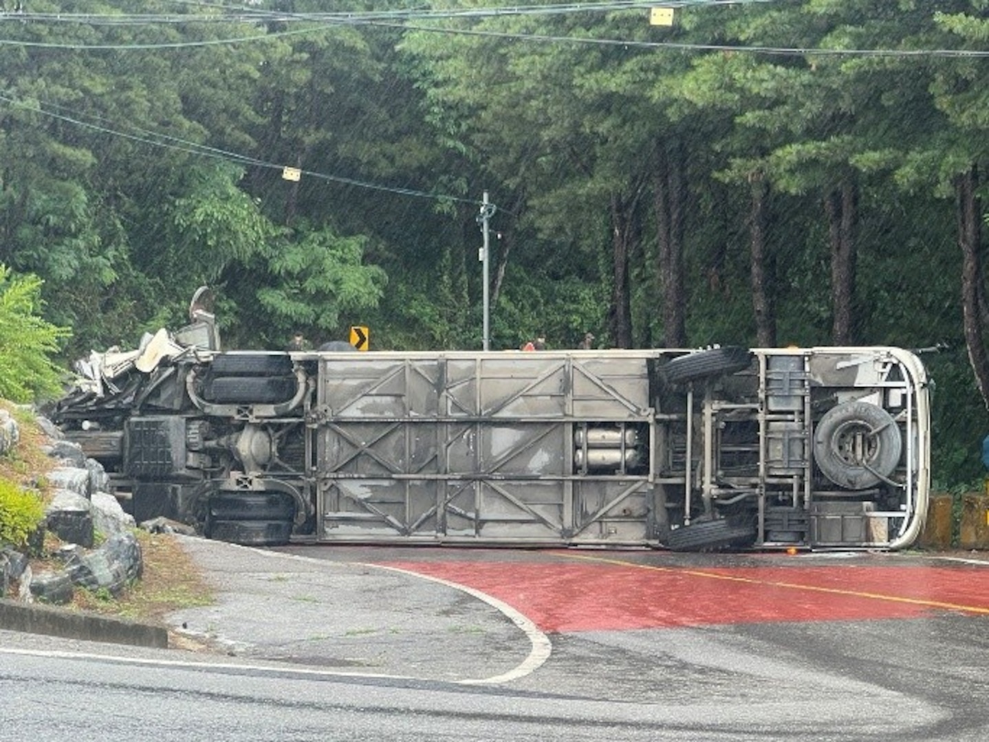 A tour bus sits overturned on a roadway in Paju, Republic of Korea, June 20, 2026. Off-duty U.S. Airmen and Soldiers sprang into action after the bus overturned, assisting injured passengers until emergency services arrived.