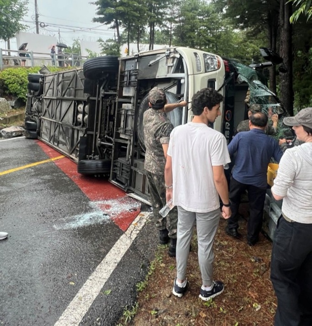 A tour bus sits overturned on a roadway in Paju, Republic of Korea, June 20, 2026. Off-duty U.S. Airmen and Soldiers sprang into action after the bus overturned, assisting injured passengers until emergency services arrived.
