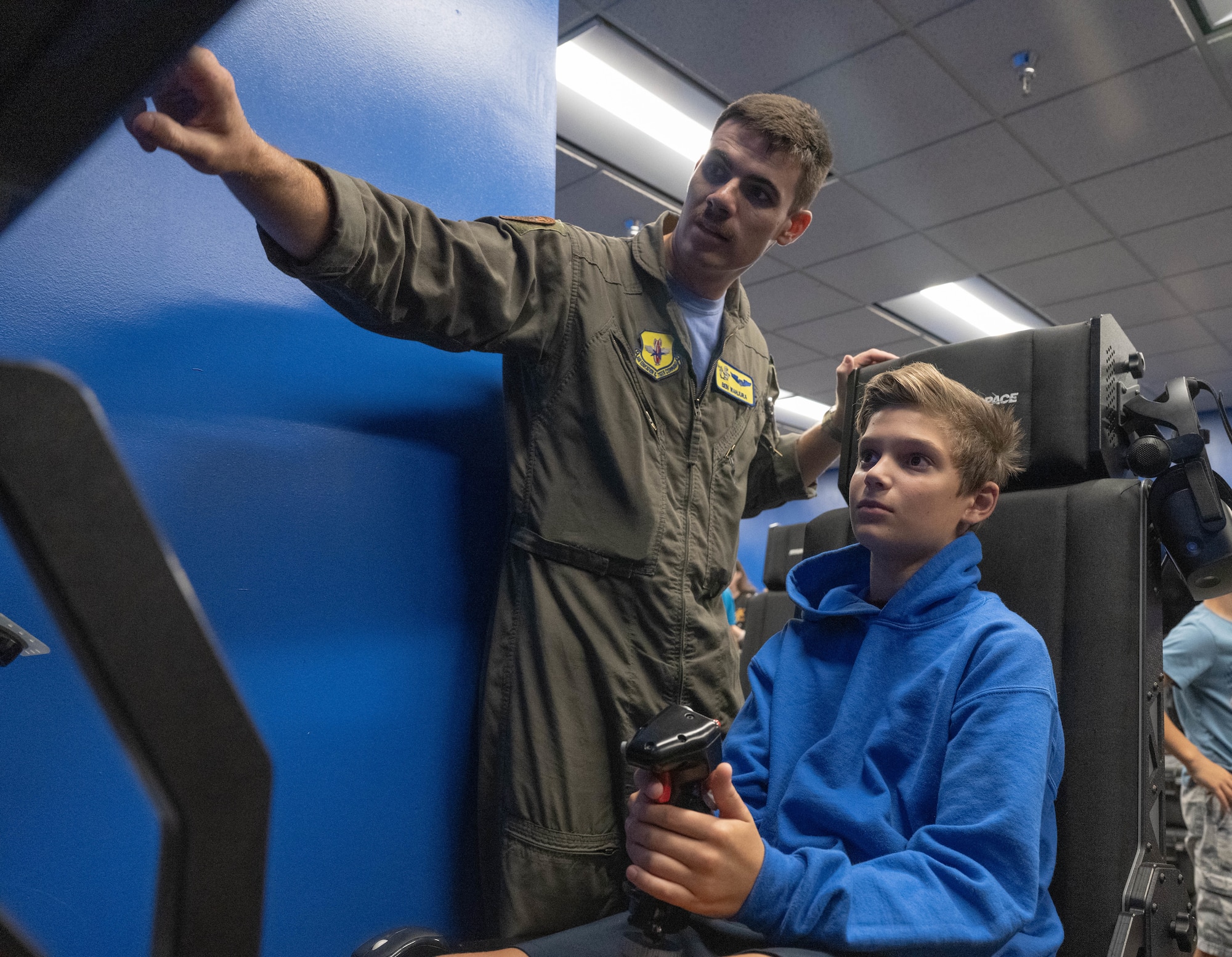 U.S. Air Force 1st Lt. Ben Wanjura, 85th Flying Training Squadron instructor pilot, gives advice to a participant of Tiger for a Day piloting a flight simulator at Laughlin Air Force Base, Texas, Aug. 5, 2026. Participants were able to fly a simulated T-6A Texan II with real-time instruction from experienced aviators. (U.S. Air Force photo by Airman 1st Class Darryl Keith)