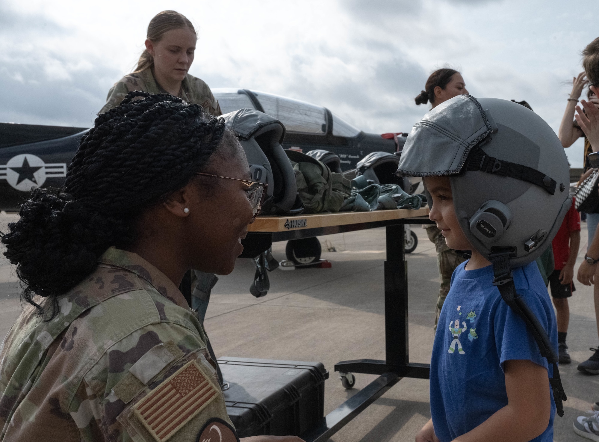 U.S. Air Force Airman 1st Class Imajanae Moses, 47th Operations Support Squadron air crew flight equipment specialist, places a flight helmet atop a Tiger for a Day participant at Laughlin Air Force Base, Texas, August 5, 2026. Partcipants were able to try on various flight equipment during the Tiger for a Day event. (U.S. Air Force photo by Airman 1st Class Darryl Keith)