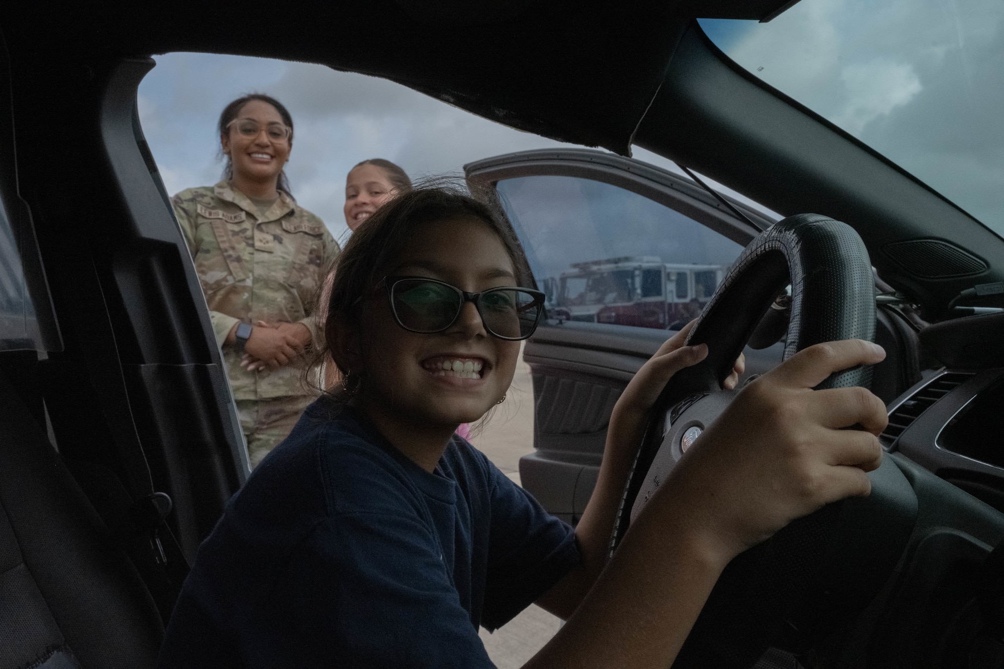 A participant for Tiger for a Day sits inside a 47th Security Forces Squadron (SFS) patrol car at Laughlin Air Force Base, Texas, August 5, 2026. The 47th SFS allowed Tiger for a Day participants to learn about their equipment and daily operations. (U.S. Air Force photo by Airman 1st Class Darryl Keith)