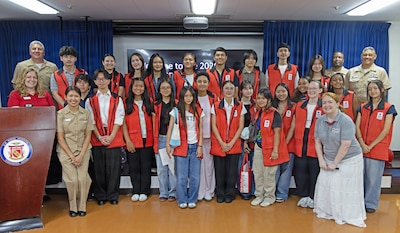 YOKOSUKA, Japan (July 31, 2026) – Capt. Joshua Miller, commanding officer of U.S. Navy Medicine Readiness and Training Command (USNMRTC) Yokosuka and director of U.S. Naval Hospital (USNH) Yokosuka, and American Red Cross staff pose for a group photo with the summer VolunTEEN participants at USNH Yokosuka. Twenty-six military-affiliated teens completed the six-week program, which provides hands-on professional development and gives participants insight into military healthcare by allowing them to shadow providers in 12 different hospital departments. (U.S. Navy photo by Ai Hazama, USNMRTC Yokosuka Public Affairs)
