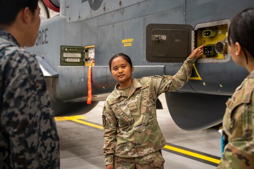 An Airman points to a part on a drone.