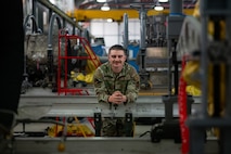 A military member leans against equipment