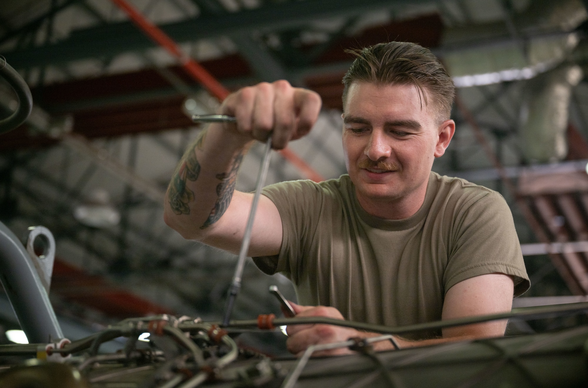 A military member works on an engine