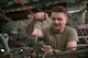 A military member works on an engine