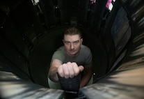 An Airman stands inside an engine