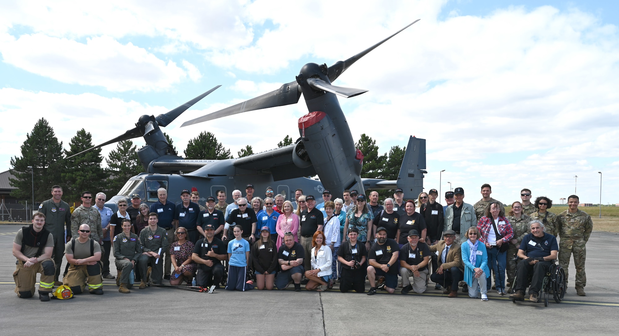 Team Mildenhall Airmen, along with SR-71 Blackbird veterans and their families, pose for a photo with a CV-22 Osprey during a visit at RAF Mildenhall, England, July 27, 2026. Veterans of the SR-71, along with their families and members of the RAF Sculthorpe Heritage Centre, received mission briefings and a tour of the base, including hangars where they once worked, and static displays. (U.S. Air Force photo by Karen Abeyasekere)