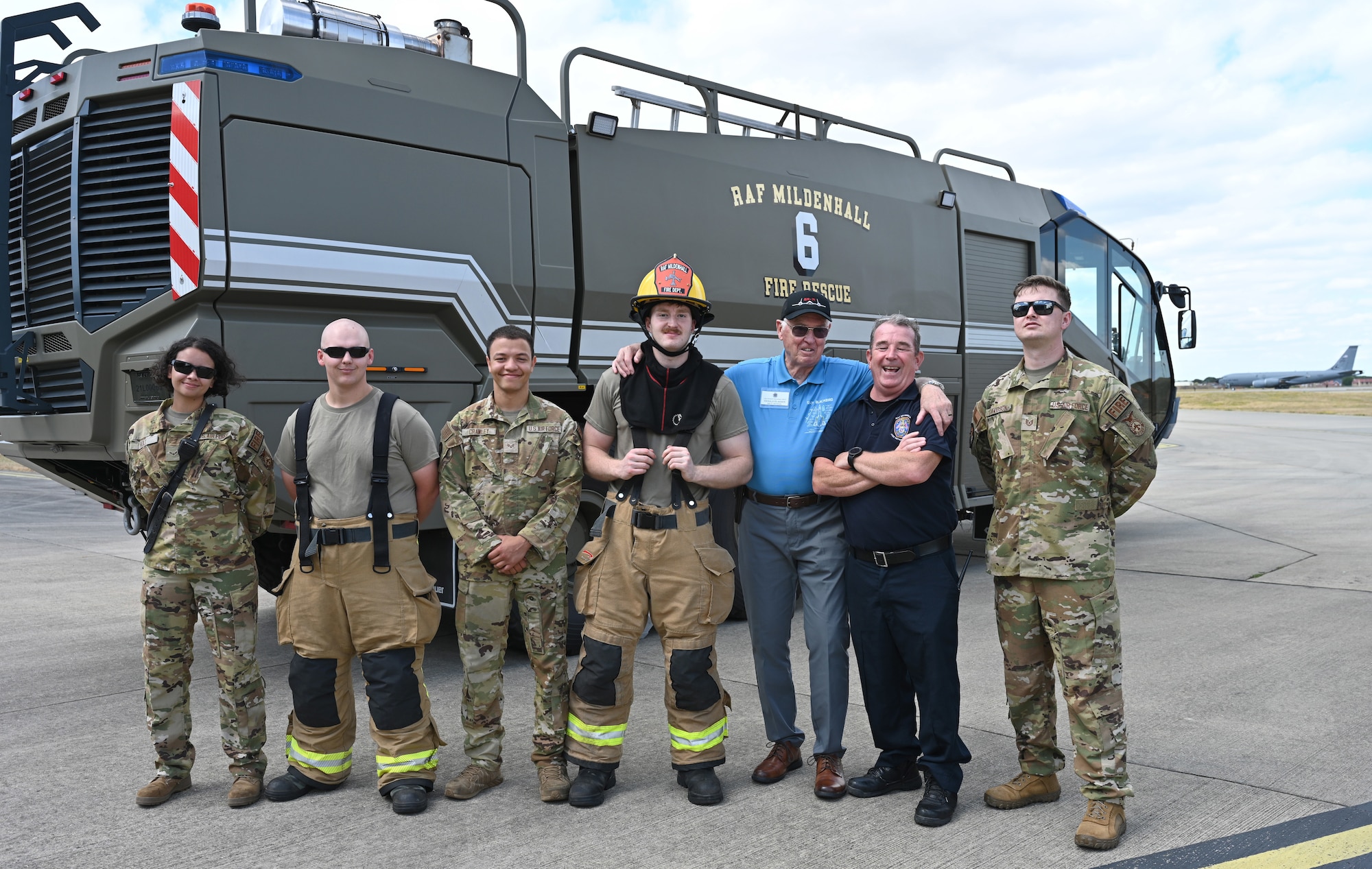 U.S. Air Force and British civilian firefighters from the 100th Civil Engineer Squadron Fire Department pose for a photo with Lt. Col. (ret.) Gerald Glasser, former SR-71 Blackbird pilot, during a visit of SR-71 veterans and their families to RAF Mildenhall, England, July 27, 2026. The fire department, along with 100th Security Forces Squadron members and other Team Mildenhall units,g participated in a static display event for the SR-71 veterans, demonstrating the mission sets of the 100th Air Refueling Wing and 352nd Special Operations Wing. (U.S. Air Force photo by Karen Abeyasekere)
