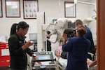 U.S. Navy Hospital Corpsman 2nd Class Kezia Allegue Navarro, left, a radiologic technologist, operates portable X-ray equipment while medical personnel evaluate a simulated casualty during a mass casualty exercise at U.S. Naval Hospital Rota, Naval Station Rota, Spain, June 25, 2026. The training tested patient assessment, diagnostic imaging procedures and coordinated care during a large-scale emergency response. (U.S. Navy photo by Hospital Corpsman 2nd Class Ahmi Atsina)
