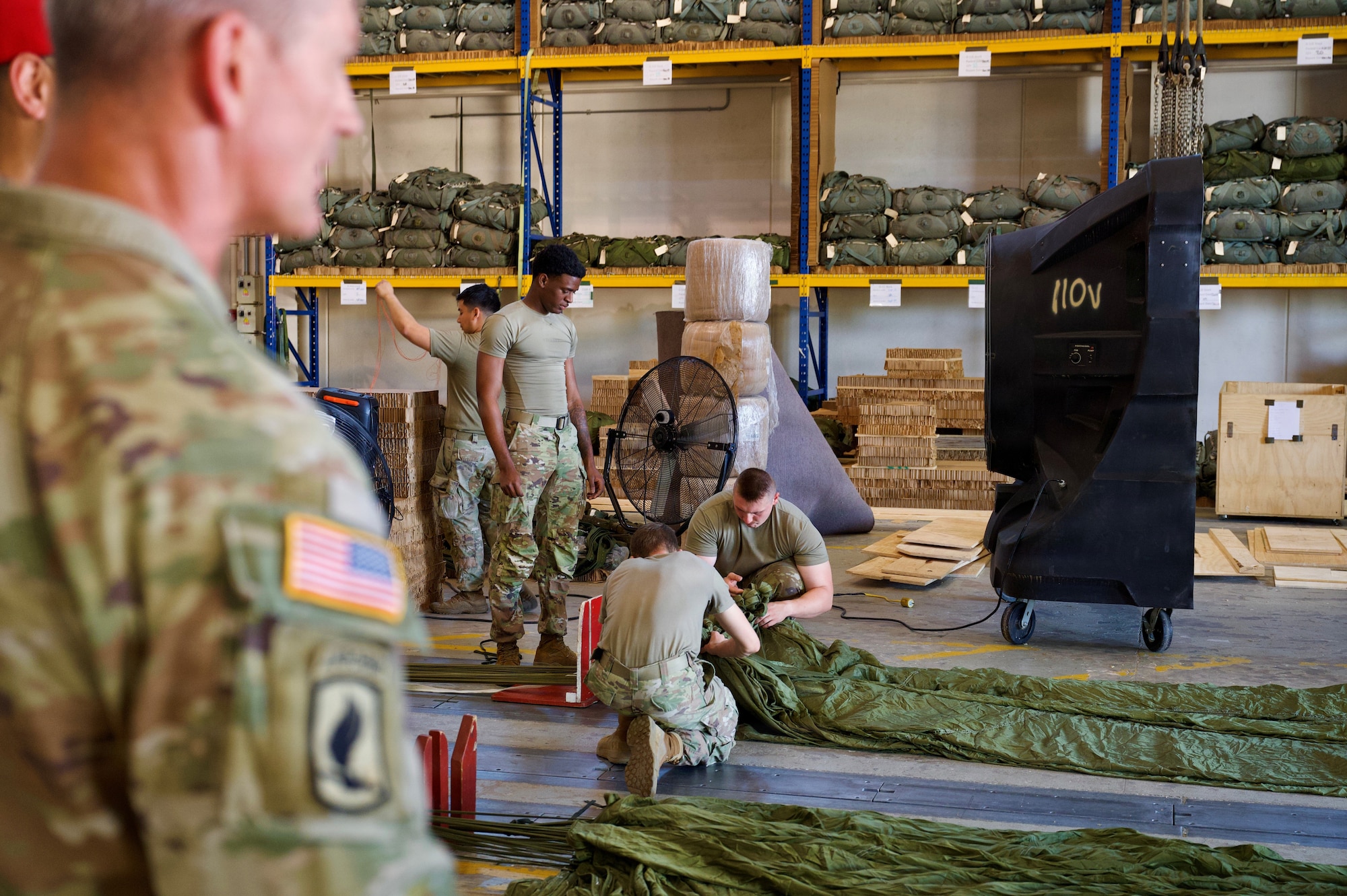 A service member watches soldiers work.