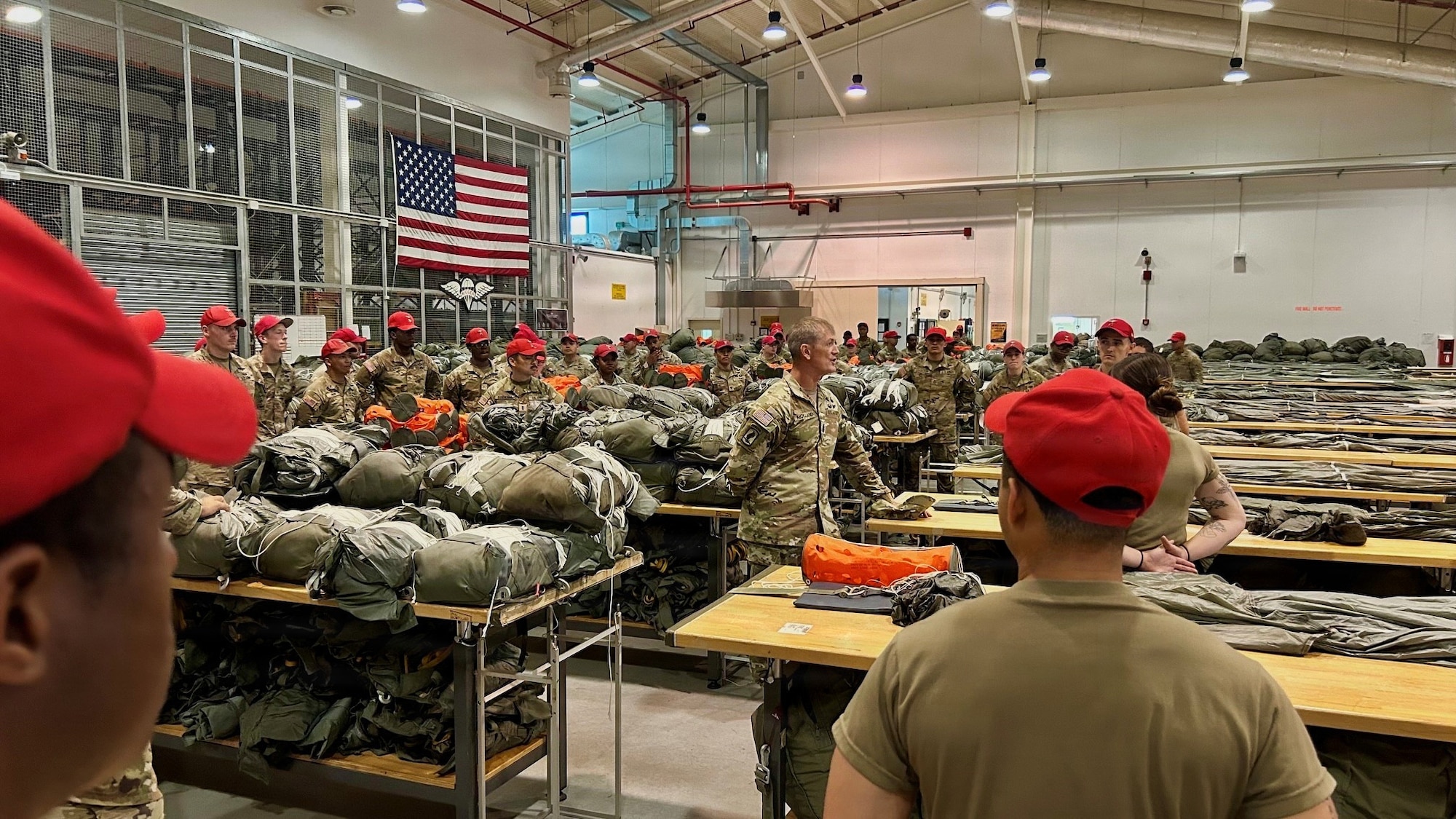 Many soldiers in red hats stand in a room.