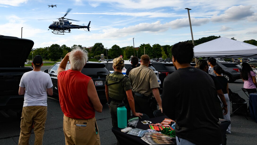 Attendees gather around a Maryland State Police helicopter during National Night Out in Baltimore