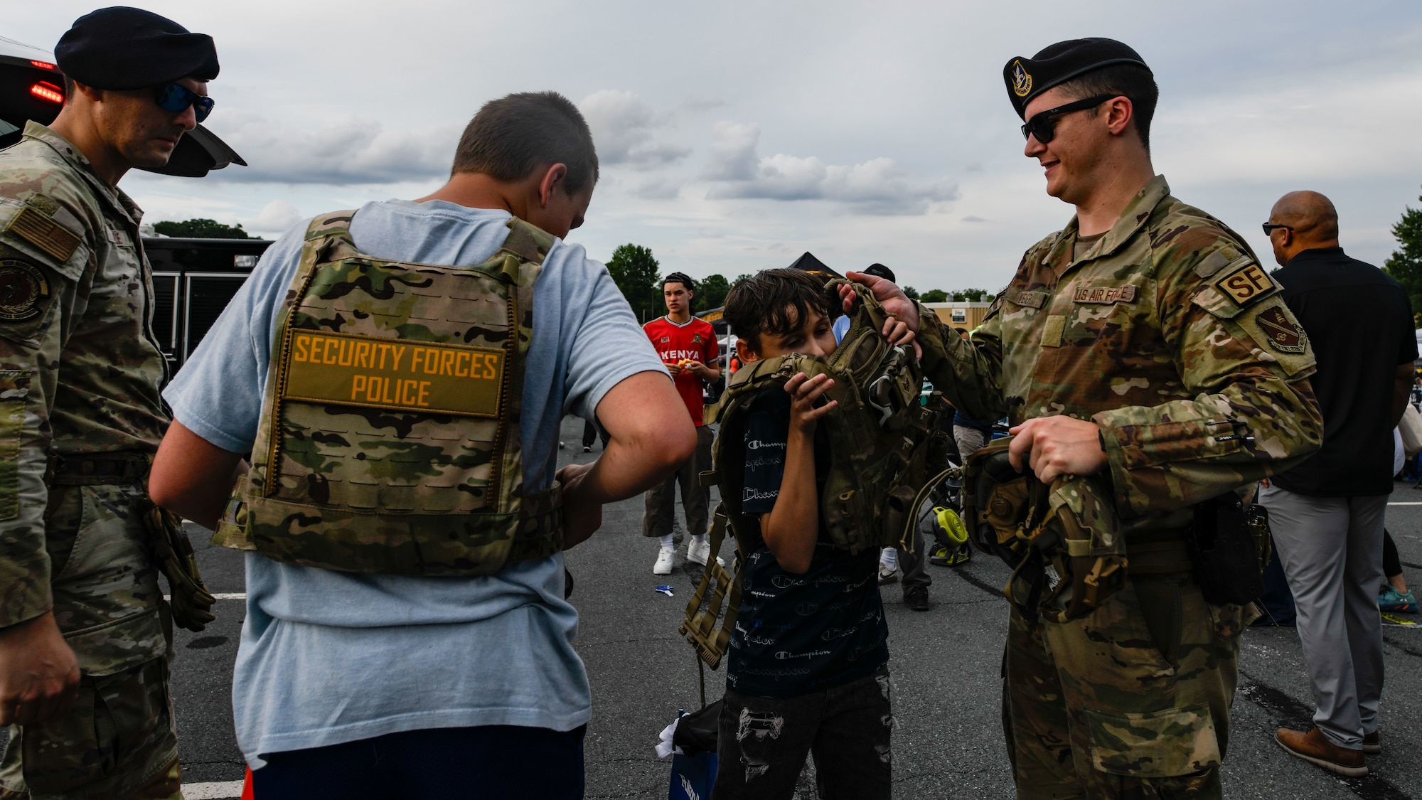 U.S. Air Force Staff Sgt. Travis A. Radle, left, 316th Security Forces Squadron police services noncommissioned officer in charge, and Staff Sgt. Ayden J. Weier, 316th Security Forces Squadron confinement noncommissioned officer in charge, interact with local youth