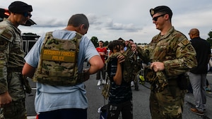 U.S. Air Force Staff Sgt. Travis A. Radle, left, 316th Security Forces Squadron police services noncommissioned officer in charge, and Staff Sgt. Ayden J. Weier, 316th Security Forces Squadron confinement noncommissioned officer in charge, interact with local youth