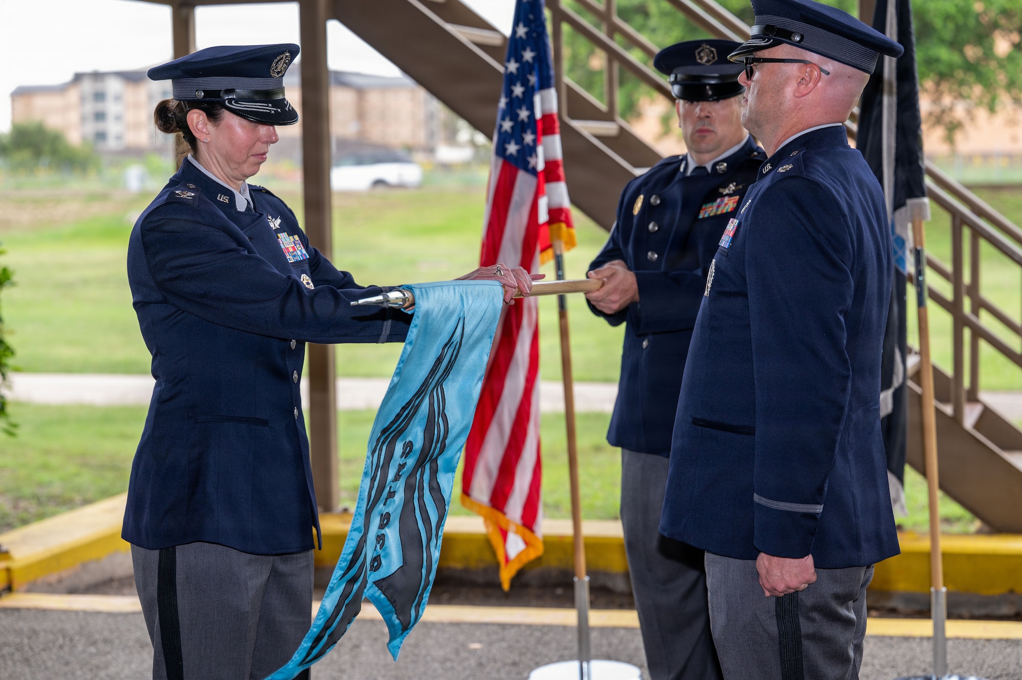Three Guardians in uniform handling guidon